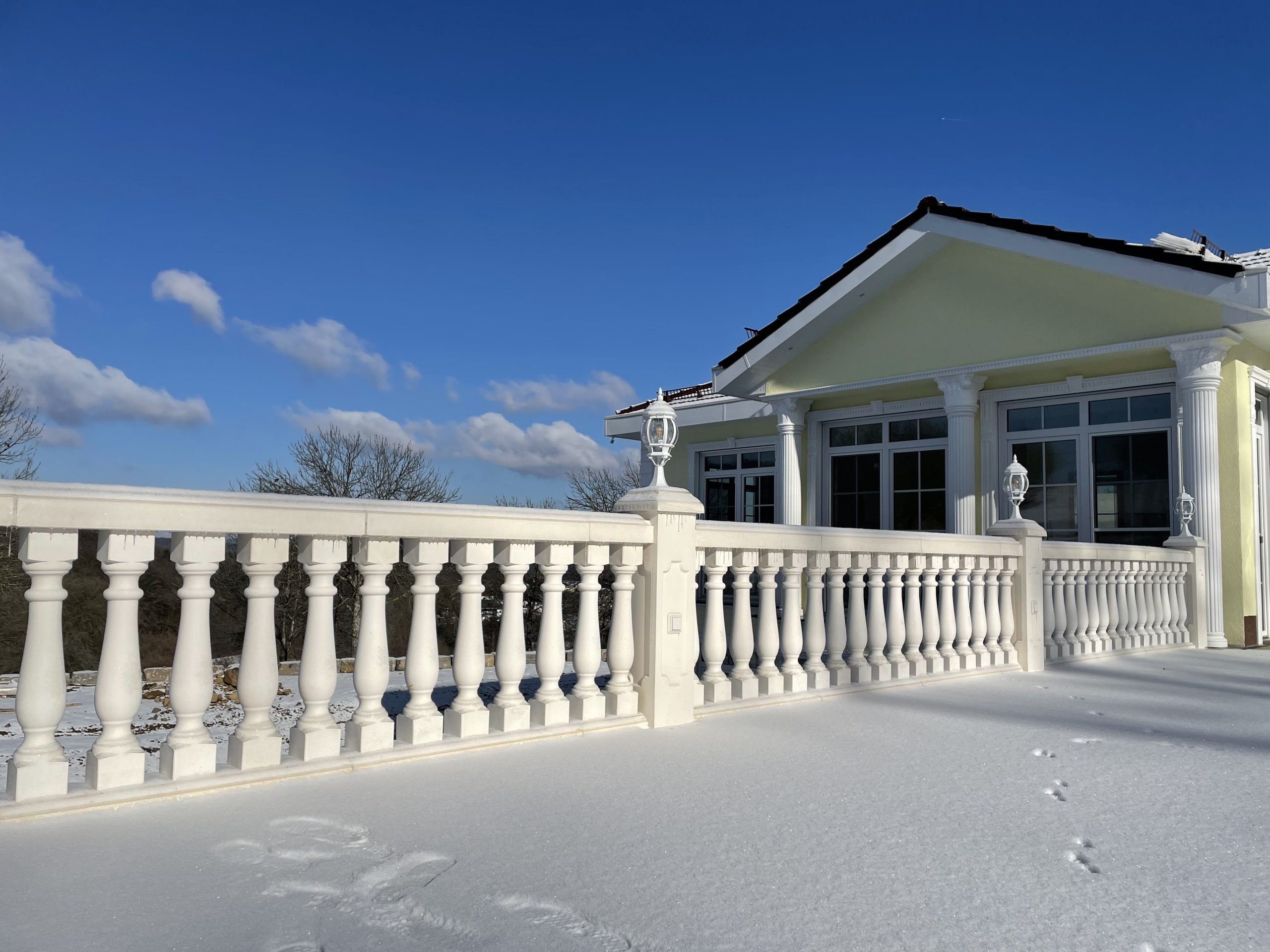 Weiße Beton-Balustrade auf schneebedeckter Terrasse